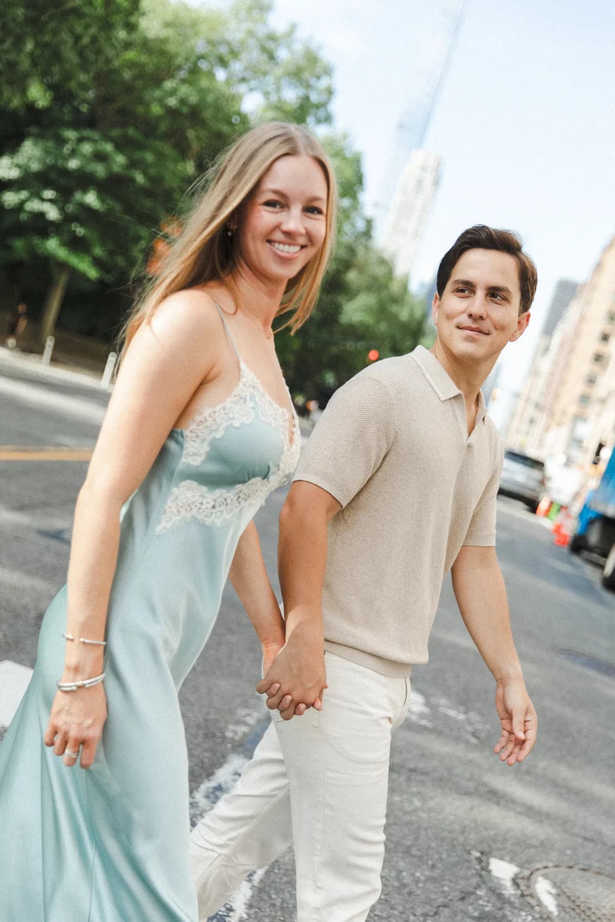 Molly and Matt holding hands while crossing a city street